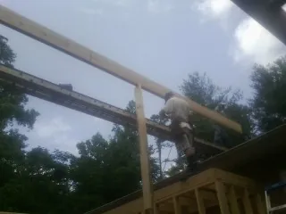 Carpenter setting a ridge beam over a new addition frame — Ice Dam Removal by Roofing Brothers in Piru