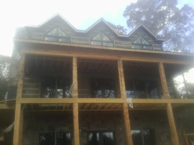 Dormers and porch framing on a large log home under construction — Roof Coating work by our crew in Piru